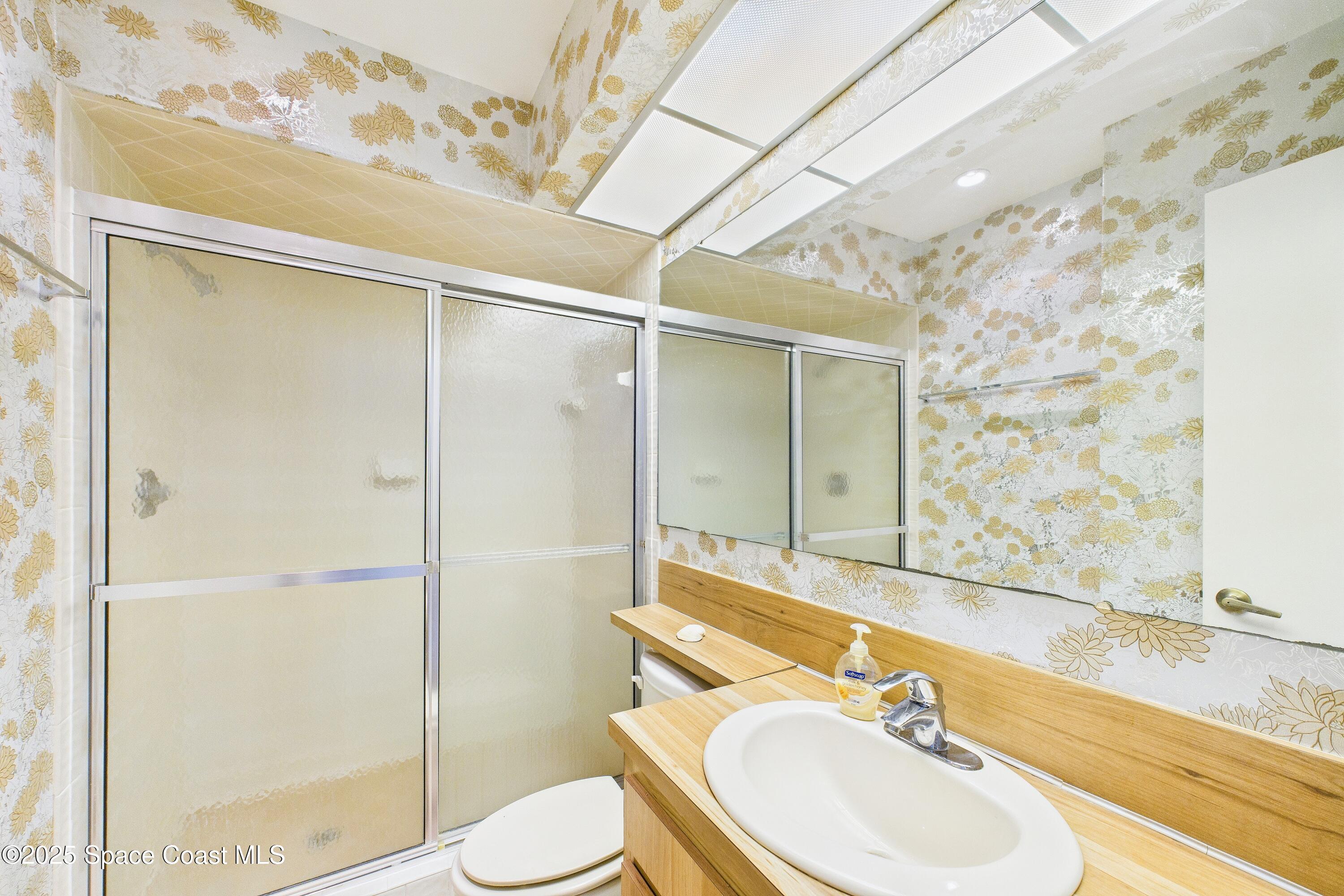 21 Cove Road, Unit 21E Melbourne Beach, FL 32951 - Photo 23 of 30 a bathroom with a sink toilet and shower