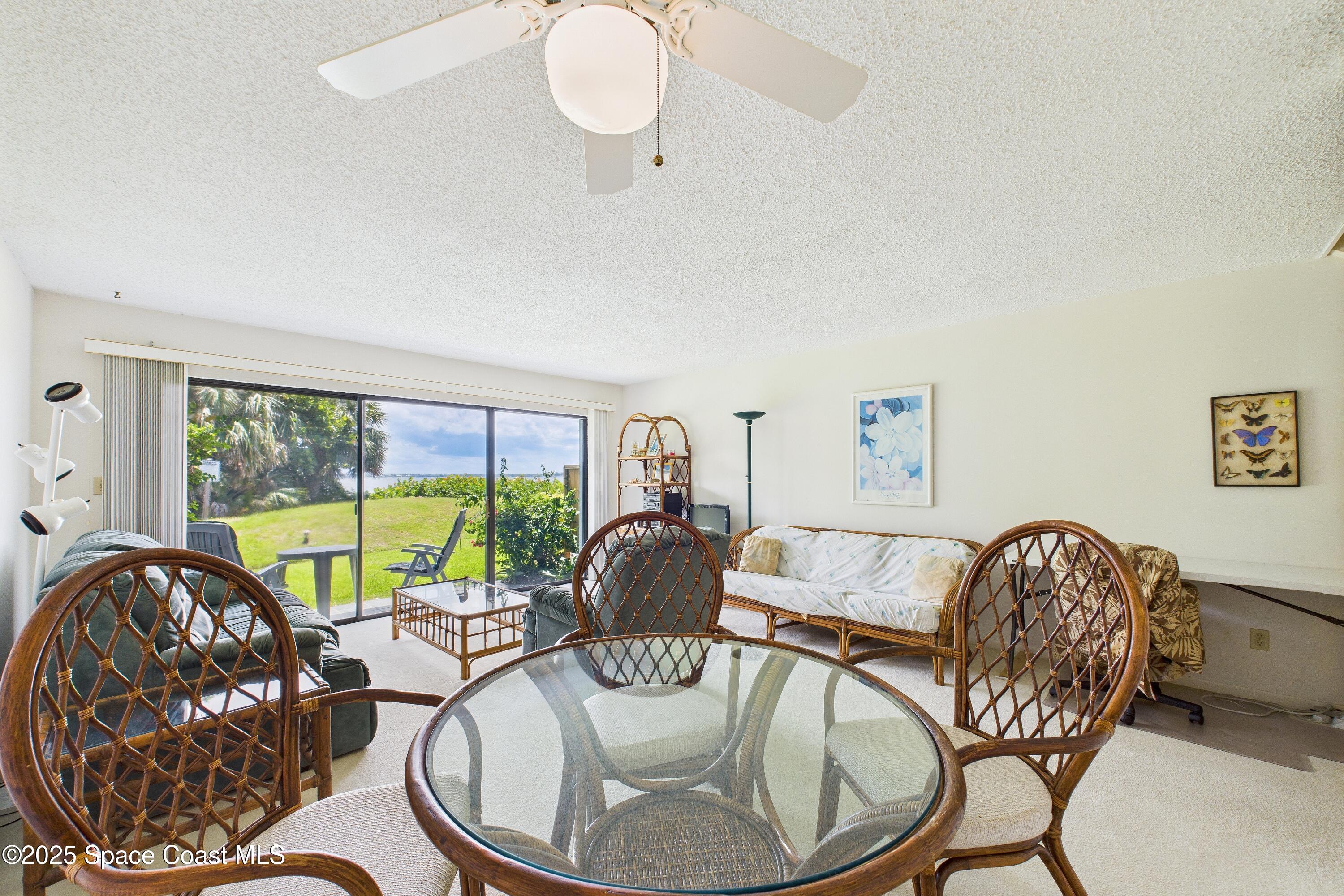 21 Cove Road, Unit 21E Melbourne Beach, FL 32951 - Photo 5 of 30 a living room with furniture and a large window