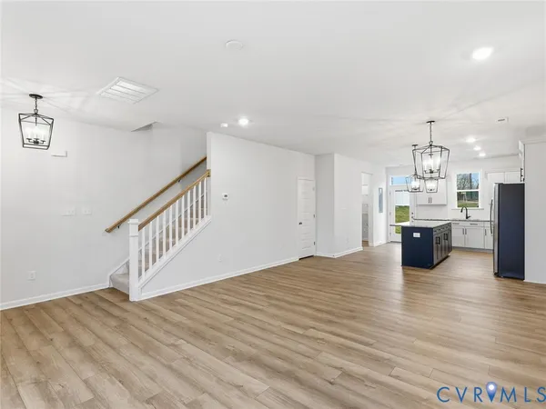 a open kitchen with white cabinets and wooden floor
