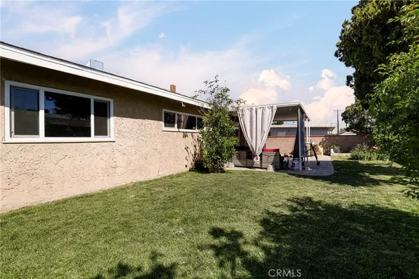 a view of a house with a big yard and large trees