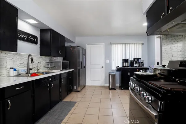 a kitchen with stainless steel appliances a sink dishwasher stove and refrigerator