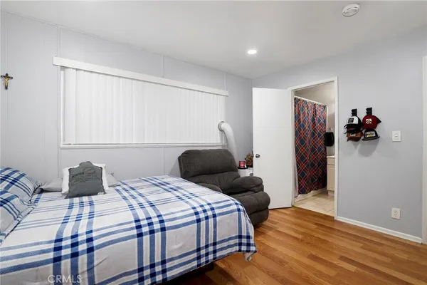 a bedroom with a bed and wooden floor