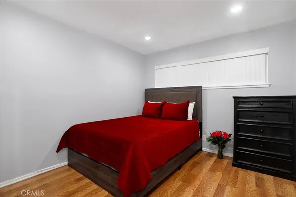a bedroom with a bed and wooden floor