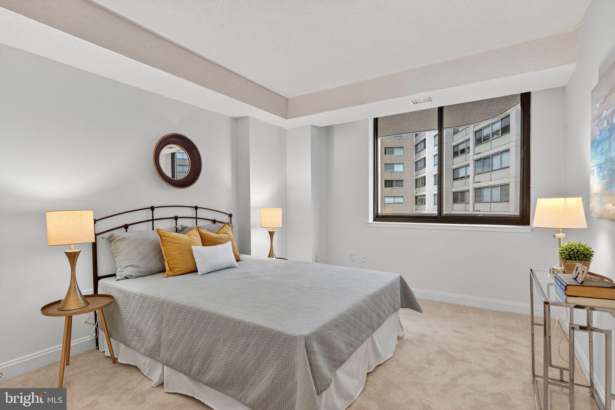 4550 North Park Avenue, Unit 814 Chevy Chase, MD 20815 - Photo 12 of 25 a bedroom with a bed and a lamp on table