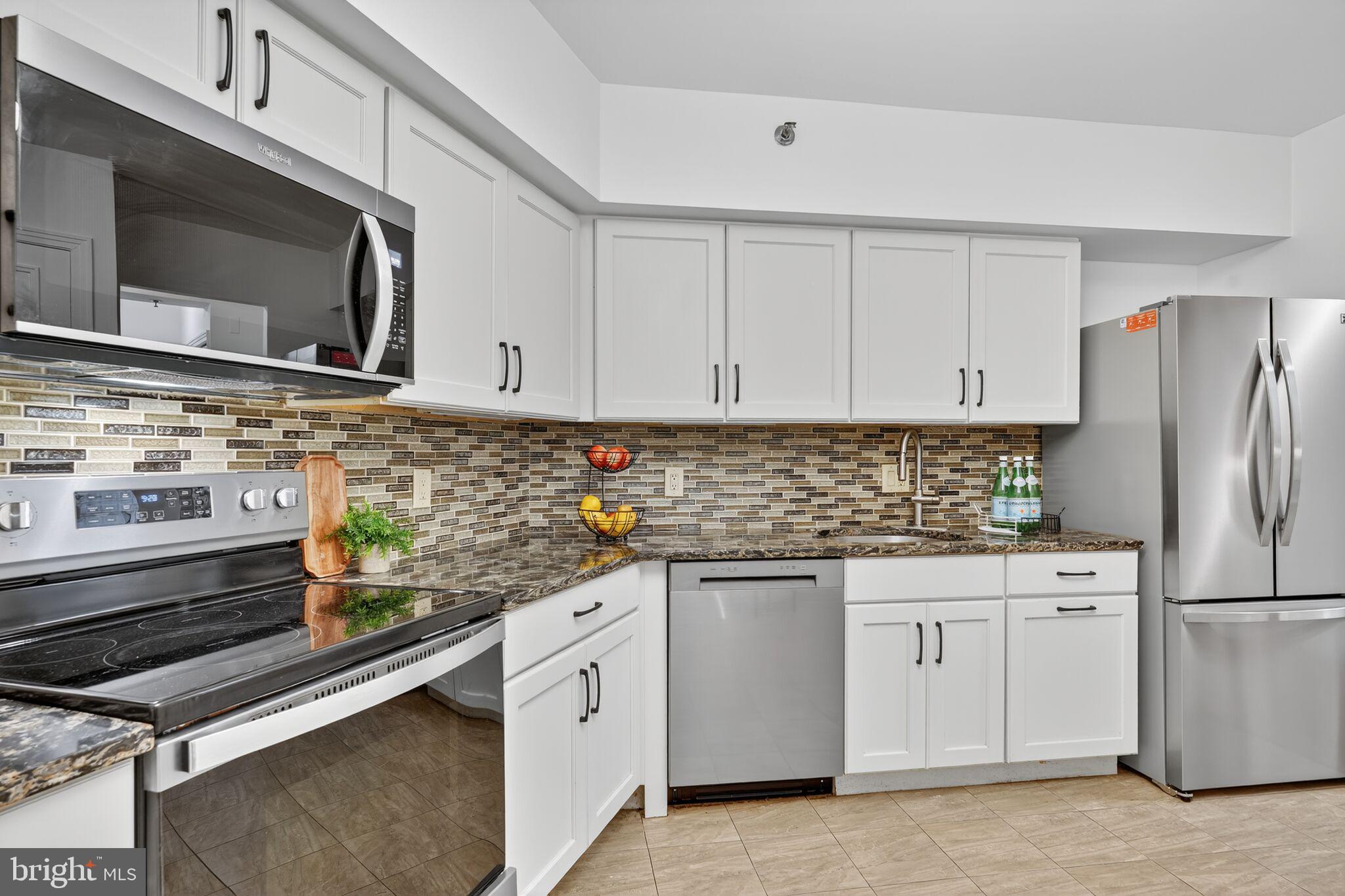 4550 North Park Avenue, Unit 814 Chevy Chase, MD 20815 - Photo 7 of 25 a kitchen with stainless steel appliances a sink stove and refrigerator