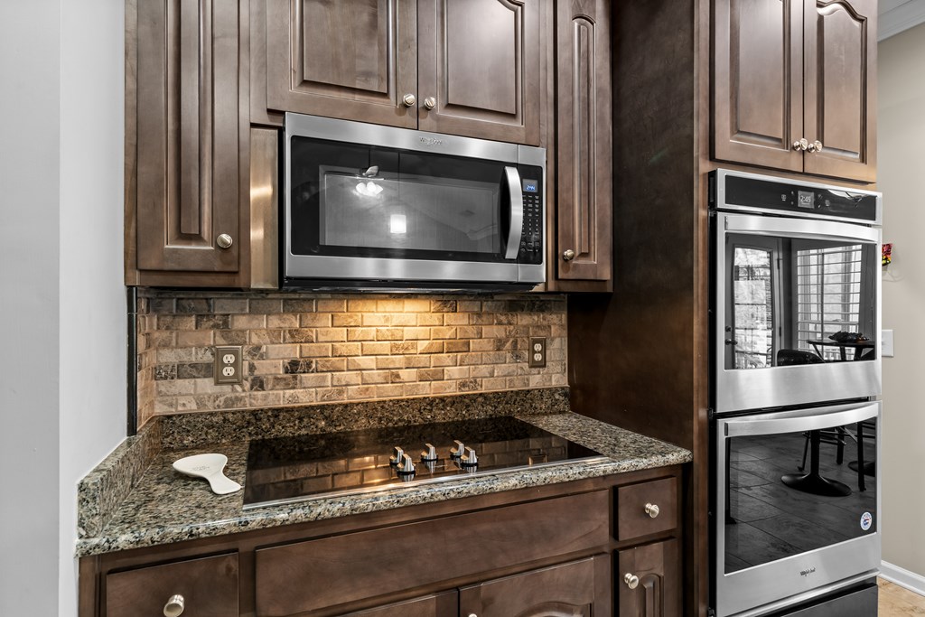 96 Morgan Trail Ellijay, GA 30536 - Photo 28 of 48 a kitchen with granite countertop a stove top oven microwave and cabinets