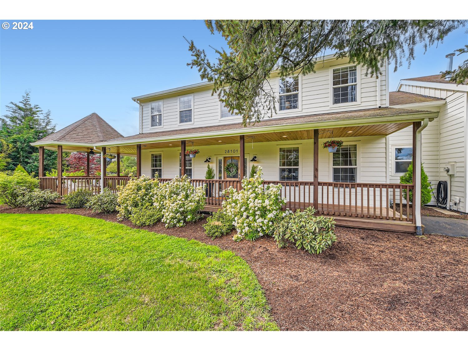 a view of a house with a yard and potted plants