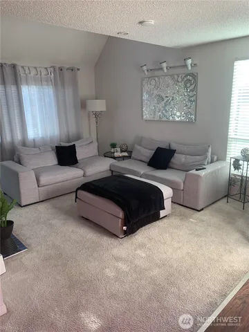 a view of a livingroom with shelves and entryway with wooden floor
