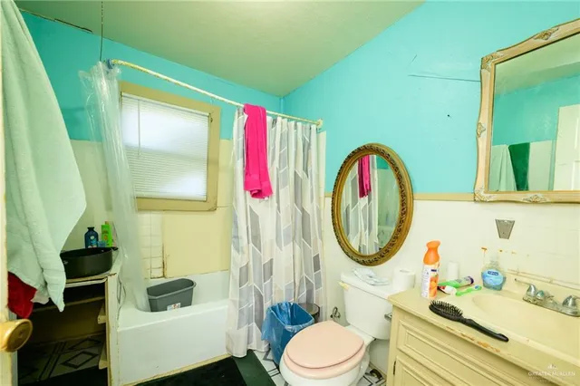 a bathroom with a toilet a sink and a mirror