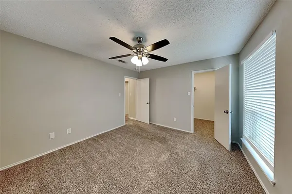 an empty room with closet and a ceiling fan