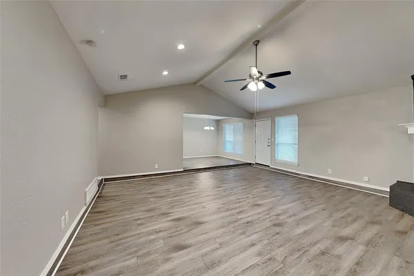 an empty room with a ceiling fan and wooden floor