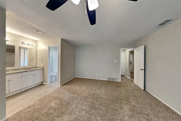 a view of an empty room with window and cabinet