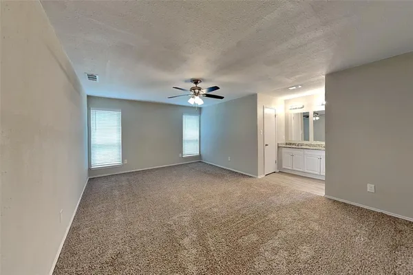 a view of a big room with windows and chandelier fan