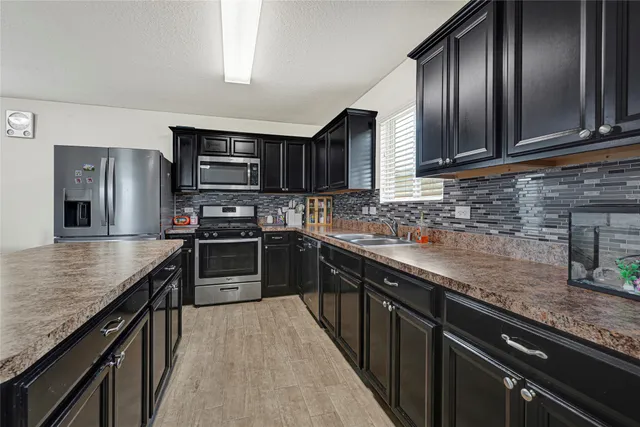 a kitchen with granite countertop stainless steel appliances and wooden cabinets