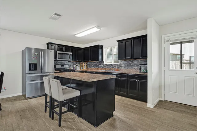 a kitchen with stainless steel appliances granite countertop a refrigerator stove microwave and sink