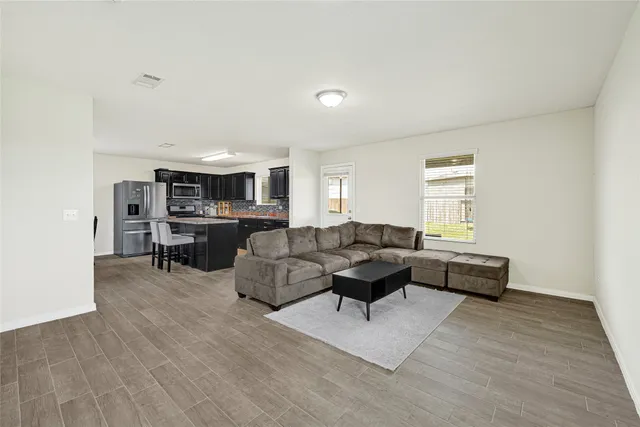 a living room with furniture and a wooden floor