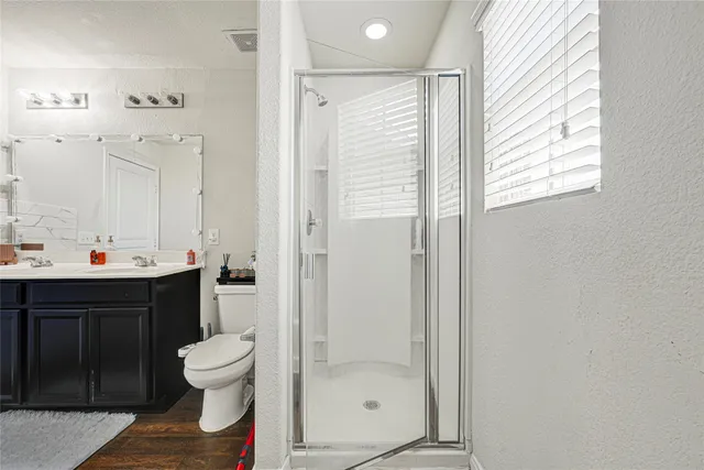 a bathroom with a sink a toilet and shower