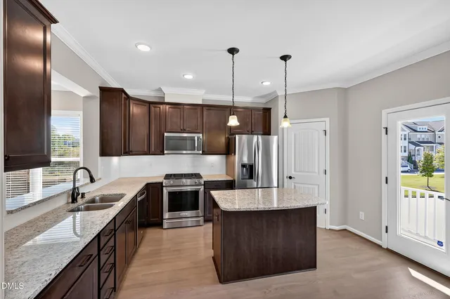 a large kitchen with kitchen island granite countertop a sink counter space a refrigerator and a sink