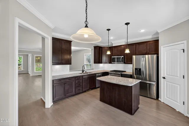 a kitchen with stainless steel appliances granite countertop a stove a refrigerator and a sink