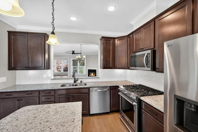 a kitchen with stainless steel appliances granite countertop a sink stove and refrigerator