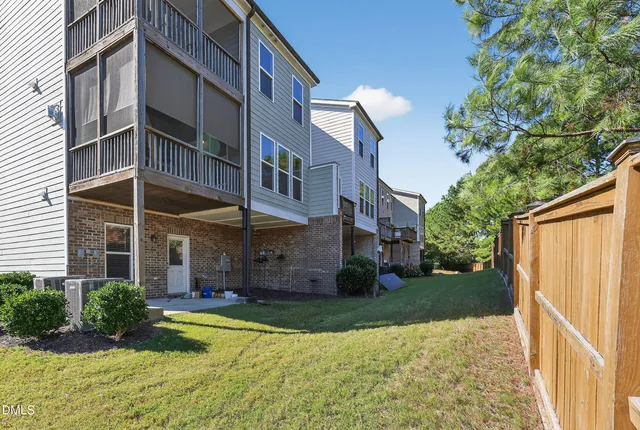 an aerial view of residential houses with outdoor space and parking