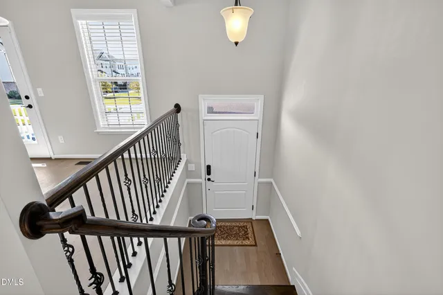 a view of staircase with railing and white walls