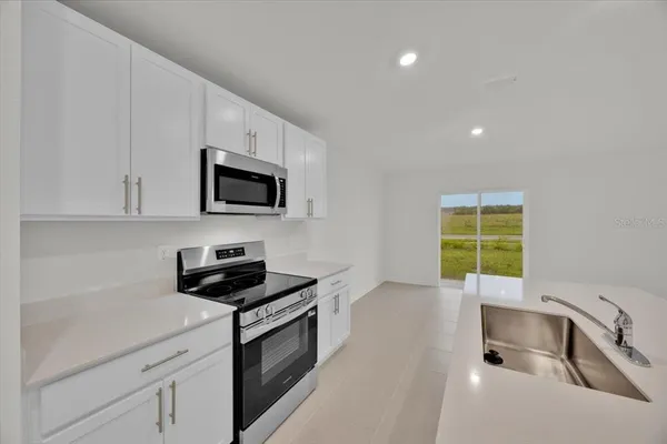 a kitchen with a sink a stove and microwave