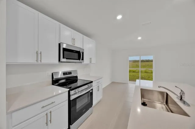 a kitchen with a sink a stove and microwave