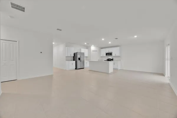 a view of large windows with white kitchen