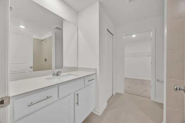 a bathroom with a granite countertop sink two mirror and a