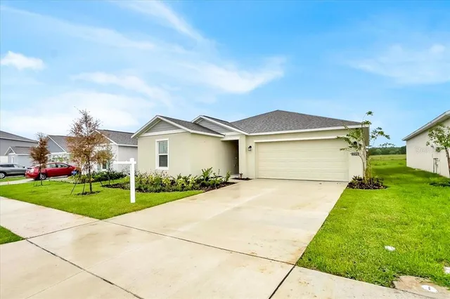 a view of a house with a yard and garage