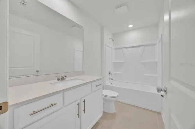 a bathroom with a granite countertop sink a toilet and shower