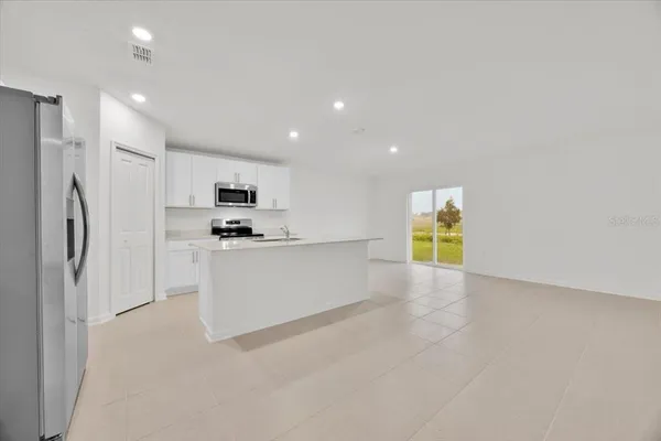 a view of kitchen with cabinets and refrigerator