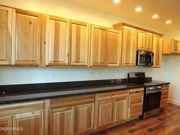 a kitchen with stainless steel appliances granite countertop a sink a stove and cabinets