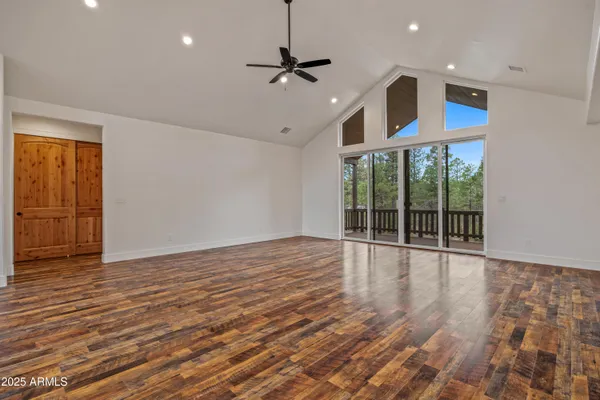 a view of an empty room with a window and wooden floor