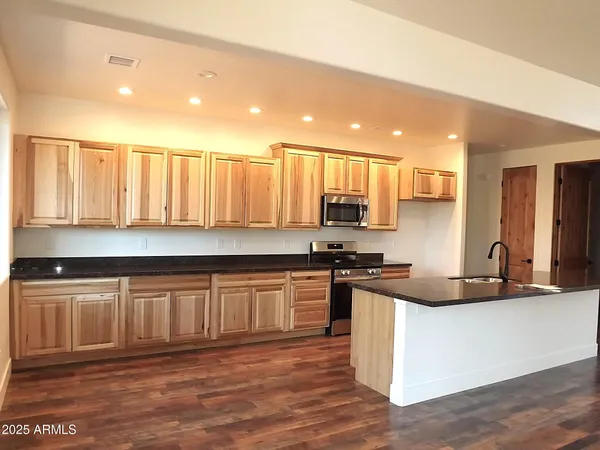 a kitchen with stainless steel appliances granite countertop a stove a sink and a granite counter tops