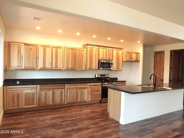 a kitchen with stainless steel appliances granite countertop a stove a sink and a granite counter tops