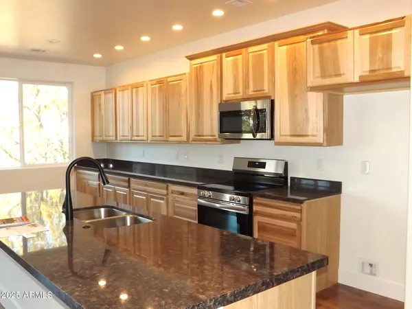 a kitchen with stainless steel appliances granite countertop a stove a sink and a microwave