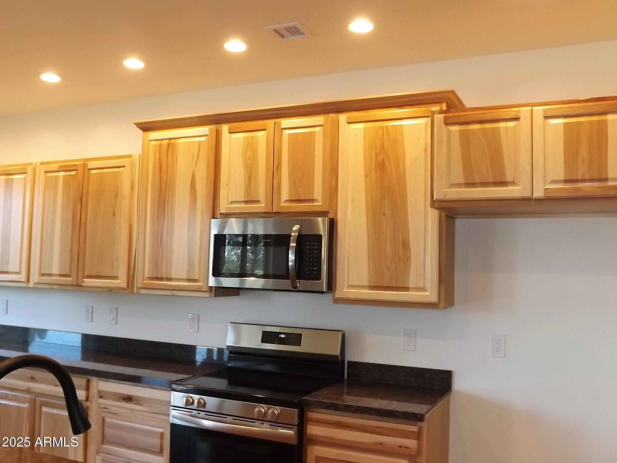 2759 Panther Circle Overgaard, AZ 85933 - Photo 9 of 11 a kitchen with stainless steel appliances granite countertop a refrigerator a stove and a microwave