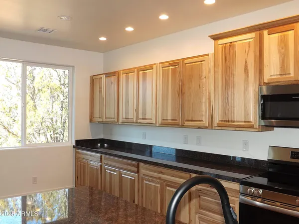 a kitchen with granite countertop a stove a sink and a counter space