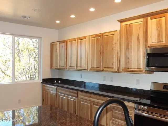 a kitchen with granite countertop a stove a sink and a counter space