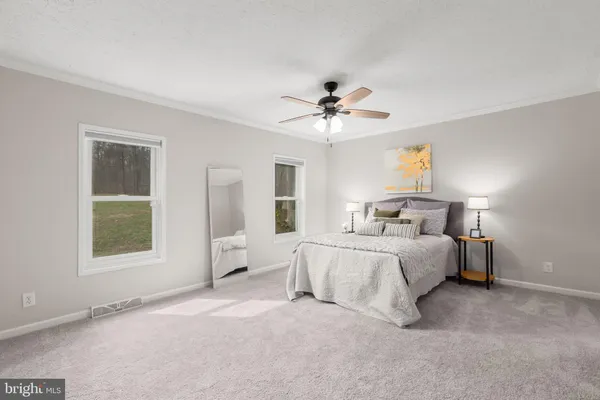 a bedroom with a bed and a chandelier fan