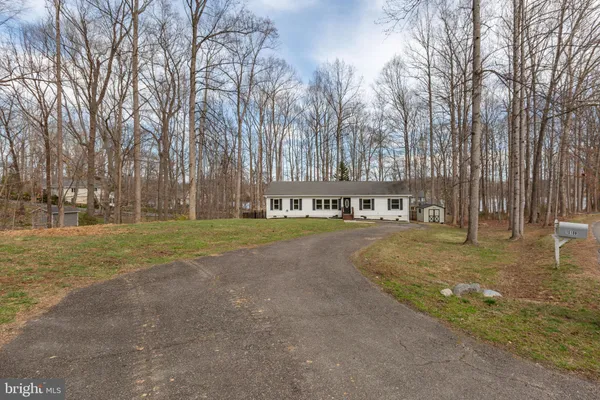 a view of a house with backyard and trees