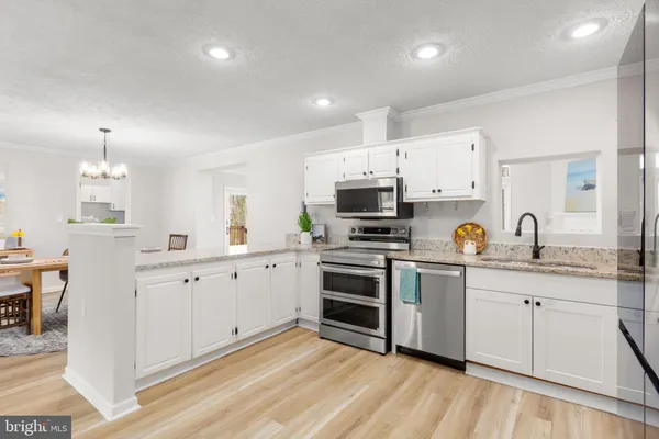 a kitchen with white cabinets stainless steel appliances and sink