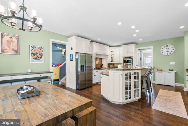 a view of a dining room with furniture a chandelier and wooden floor