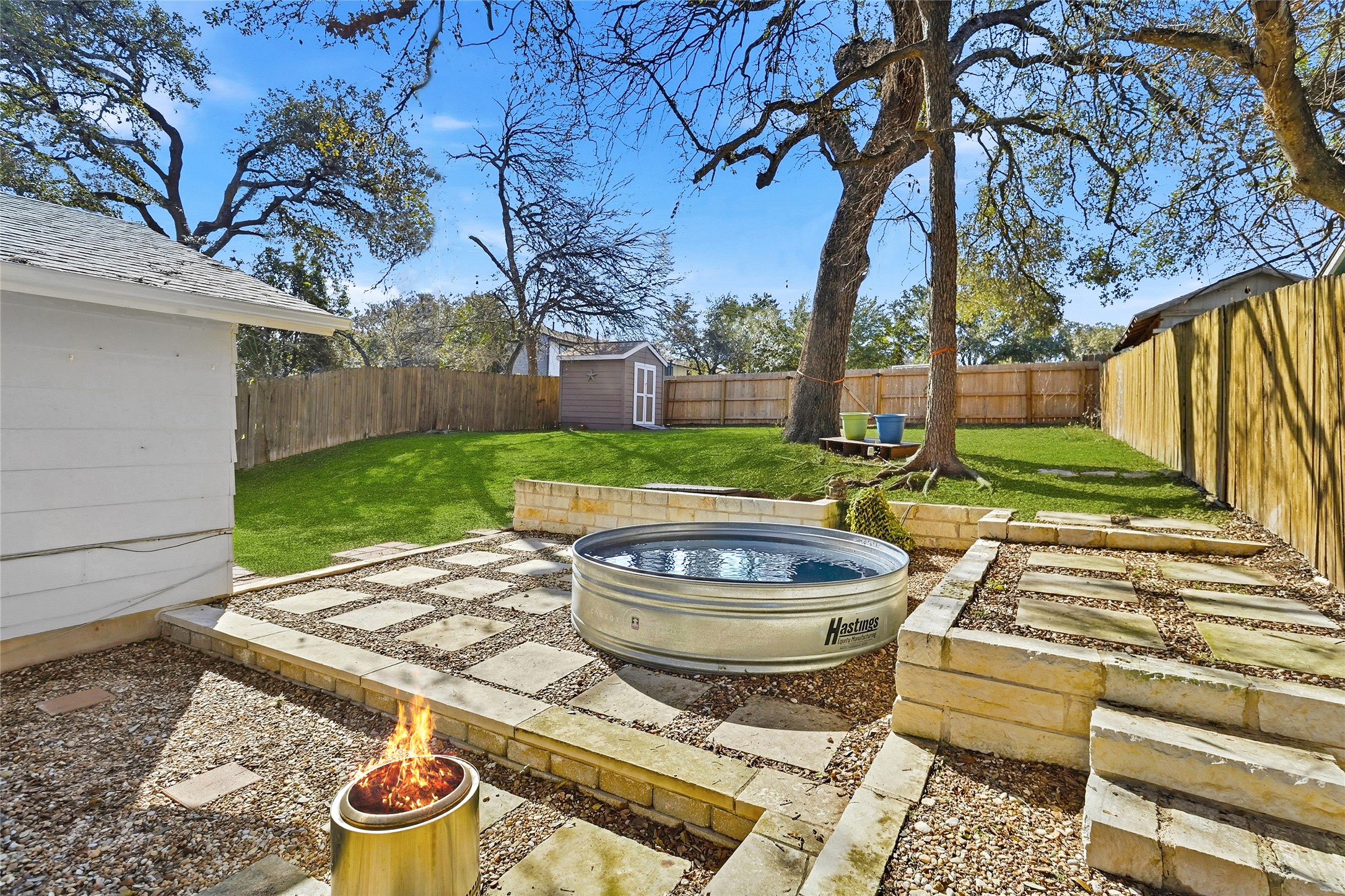 Fenced backyard featuring a shed and a patio area