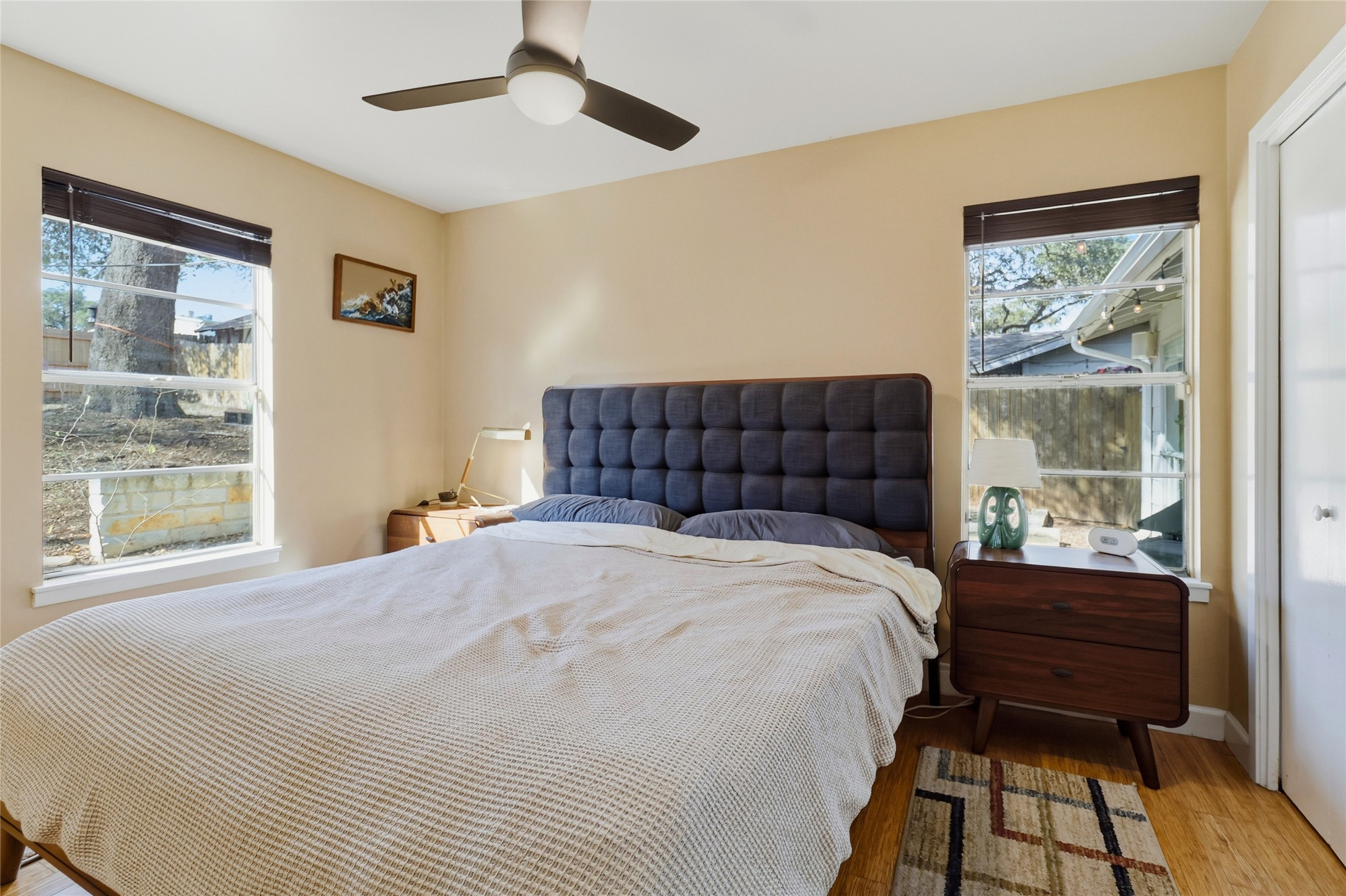 505 Lightsey Road Austin, TX 78704 - Photo 16 of 36 Bedroom featuring wood finished floors, multiple windows, and ceiling fan