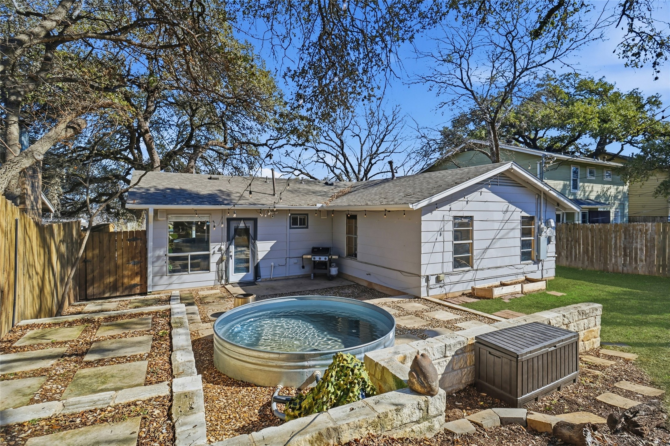 505 Lightsey Road Austin, TX 78704 - Photo 5 of 36 Rear view of house featuring a patio area, a fenced backyard, a shingled roof, and a jacuzzi