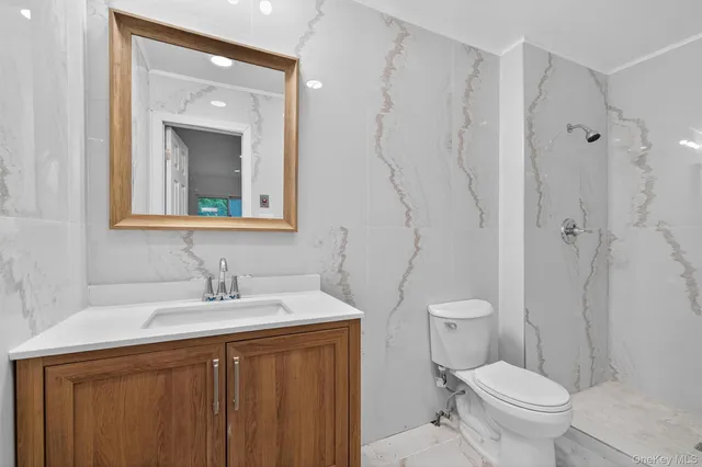 a bathroom with a toilet sink and mirror