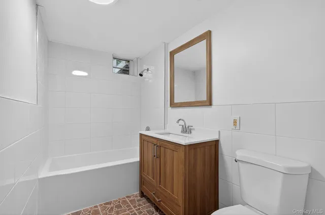 a bathroom with a toilet a sink a mirror and bathtub